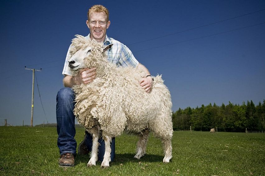 Cotswold farmer and TV presenter Adam Henson with a Cotswold Lion sheep.